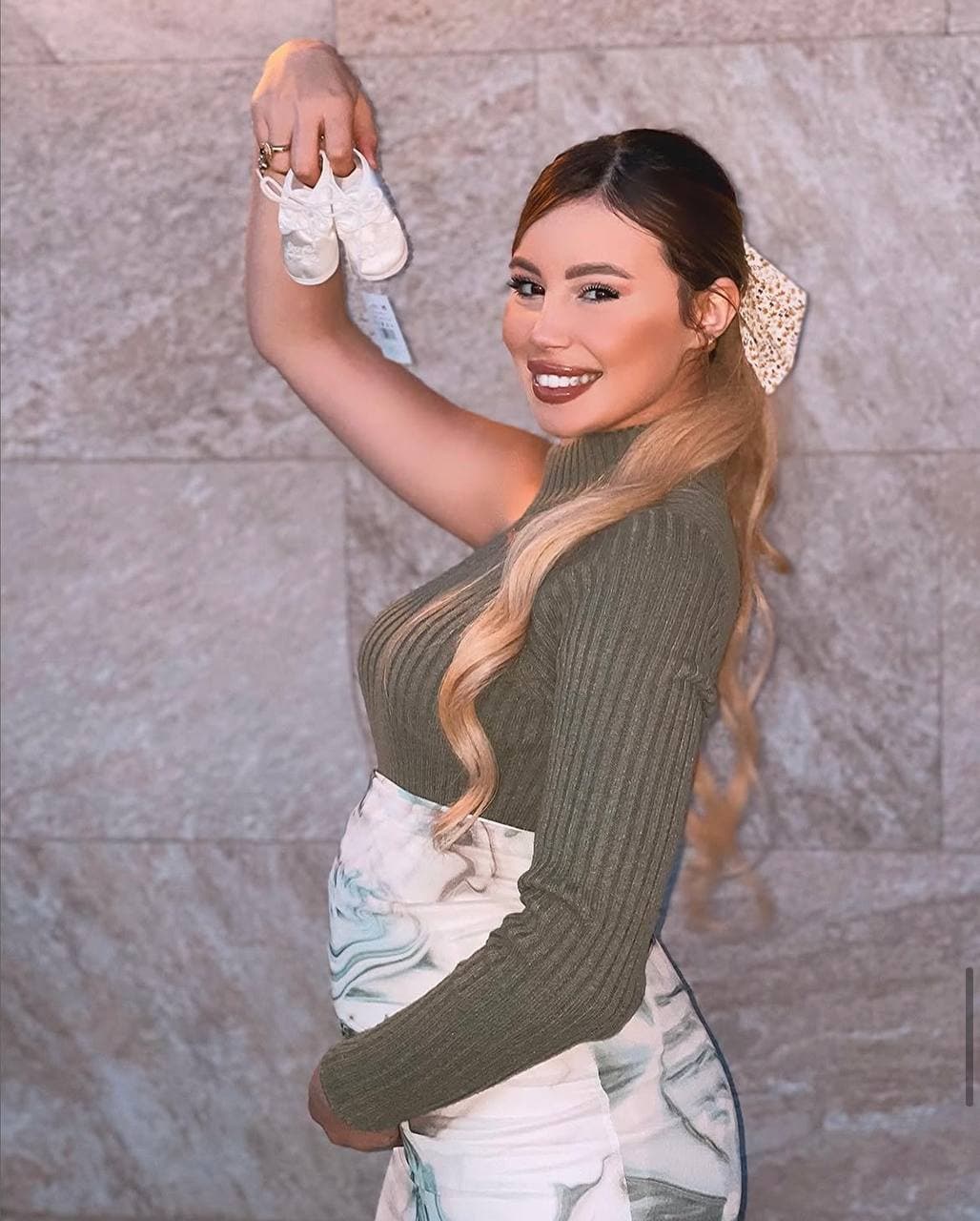 Holding a pair of baby shoes